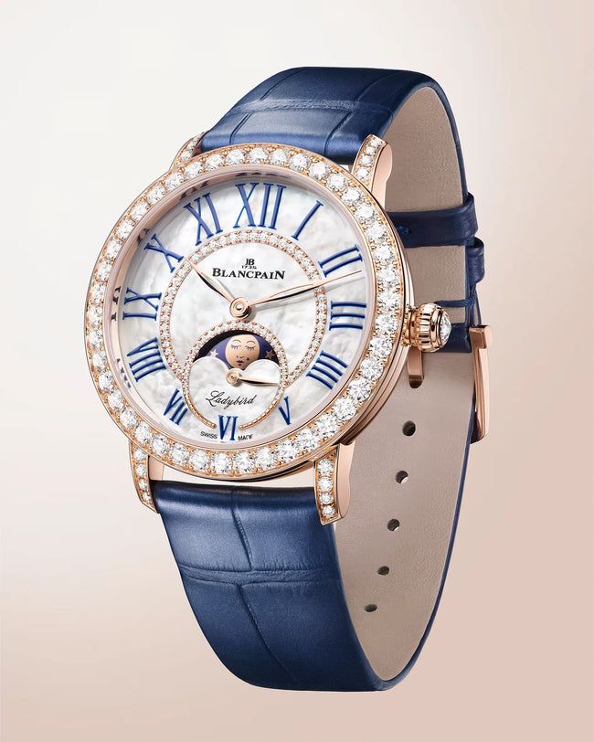 Blancpain Ladybird watch with mother-of-pearl dial, blue Roman numerals, moon phase display, diamond-set bezel, and navy alli