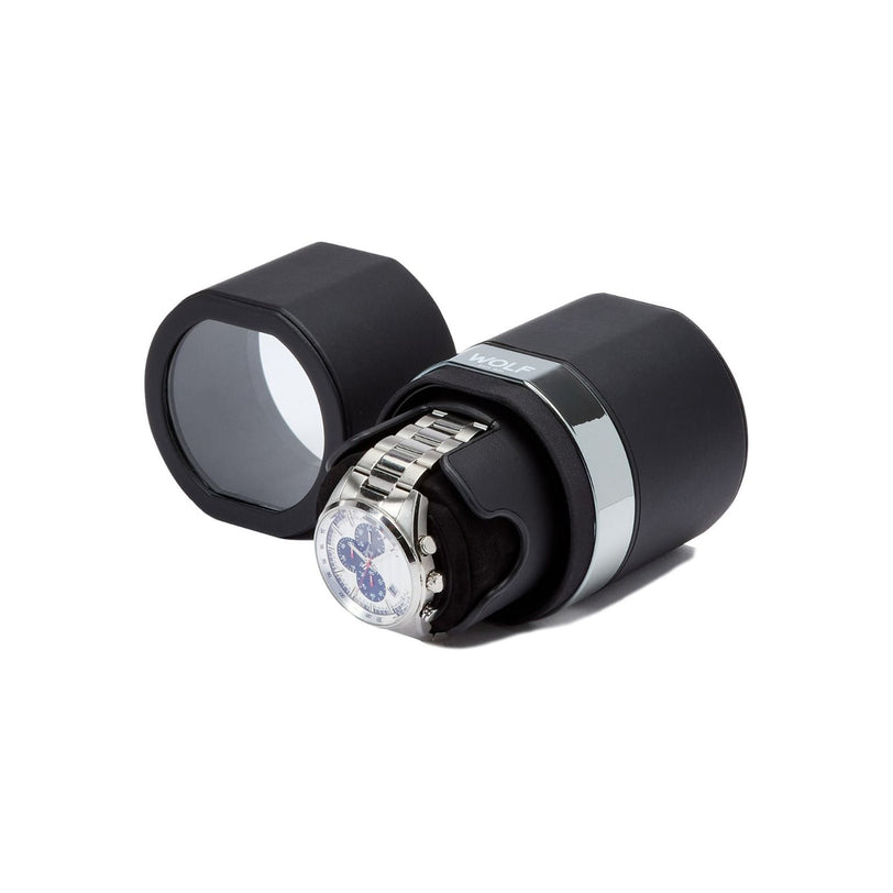 A WOLF The Rocket black cylindrical watch winder holds a silver wristwatch, displayed with the lid removed to show the watch inside.