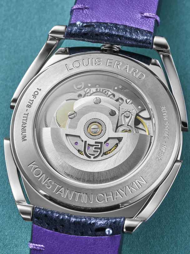 Titanium watch caseback with visible mechanical movement, purple and black leather strap, engraved with Louis Erard and Konst