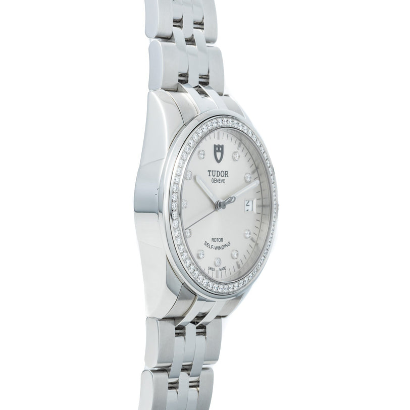 TUDOR Glamour Date wristwatch featuring a diamond bezel, metal bracelet, white dial with date display, and diamond hour markers.