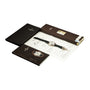 A Patek Philippe Perpetual Calendar Moonphase Chronograph wristwatch with a black band is shown with certificates, booklets, and a black folder.