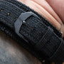 Close-up of a fabric strap with a black buckle engraved AP on a wrist, from the Audemars Piguet Royal Oak Offshore End of Days.