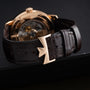 Close-up of a brown leather watch strap with a gold clasp, featuring the Vacheron Constantin Traditionnelle World Time watch face partially visible in the background.