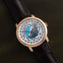 The Vacheron Constantin Traditionnelle World Time is a luxury wristwatch featuring a world map dial, city names, and a brown leather strap displayed on a dark surface.