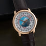 The Vacheron Constantin Traditionnelle World Time is a luxury watch featuring a gold case, brown leather strap, and an intricate map dial.