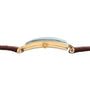 Side view of the Patek Philippe Birks Rectangular Dress Watch, featuring a gold case, brown leather strap, and a green-tinted crystal face.
