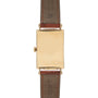The Patek Philippe Birks Rectangular Dress Watch features a blank gold face and brown leather strap.