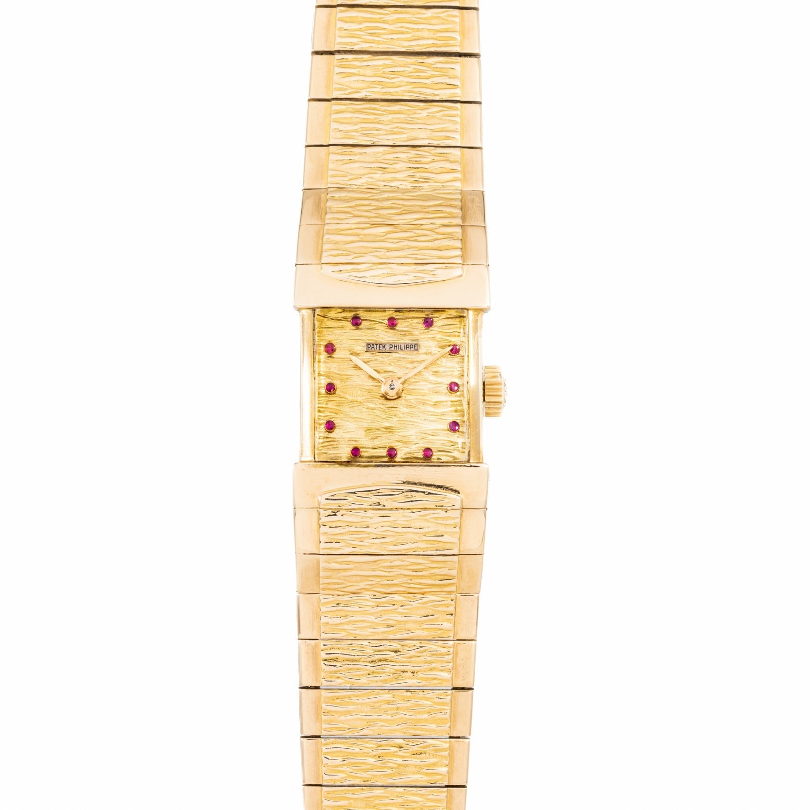 The Patek Philippe Yellow Gold Integrated Dress Watch features a rectangular case, textured band and dial, red gem hour markers, and a simple gold crown.