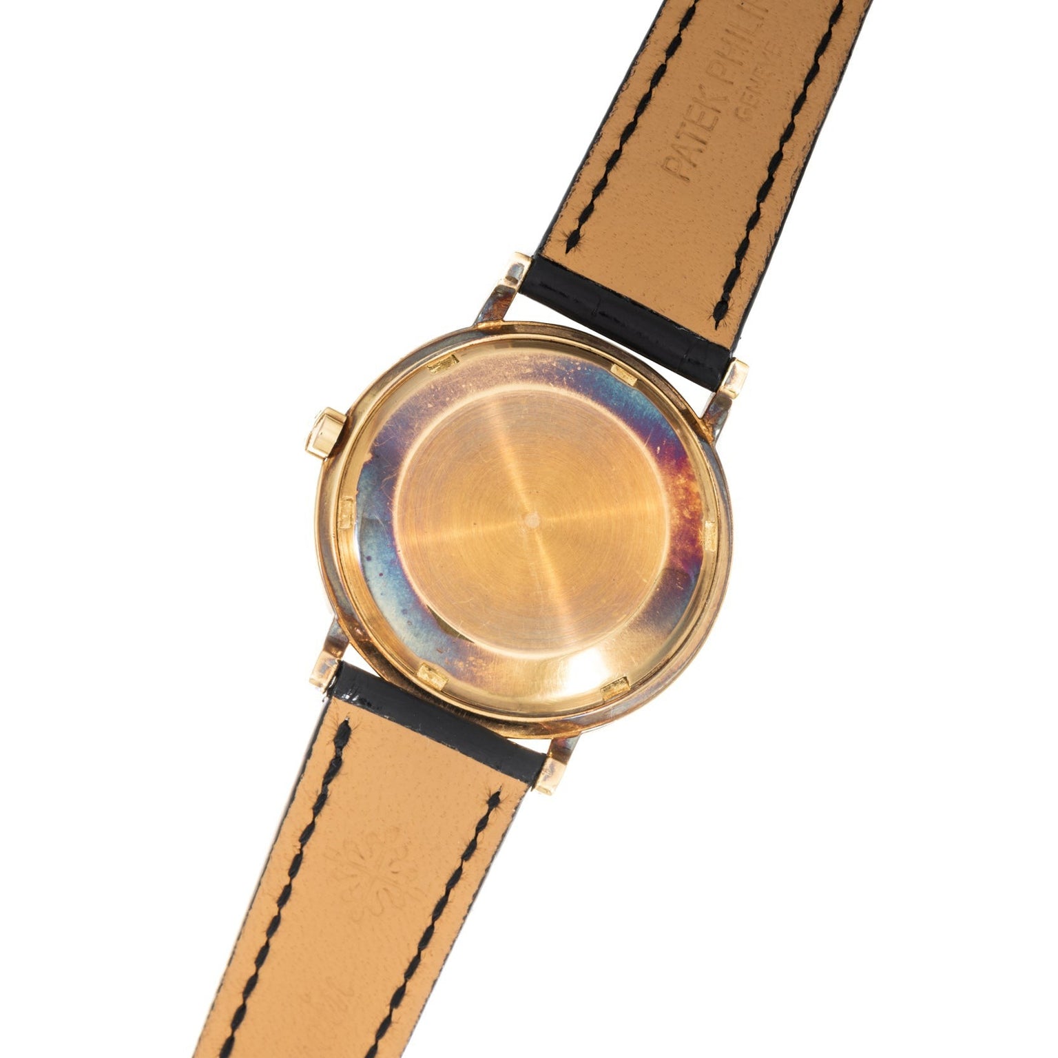 The back of a Patek Philippe Calatrava Waterproof gold wristwatch with a leather strap, featuring a circular case and no visible branding.