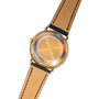 The back of a Patek Philippe Calatrava Waterproof gold wristwatch with a leather strap, featuring a circular case and no visible branding.