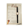 A Patek Philippe Calatrava Waterproof wristwatch with a black leather strap rests on a certificate from the manufacturer’s archives.