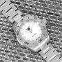 The TAG Heuer Aquaracer Ladies Mother Of Pearl watch, featuring a white face, is displayed on a woven textured surface.