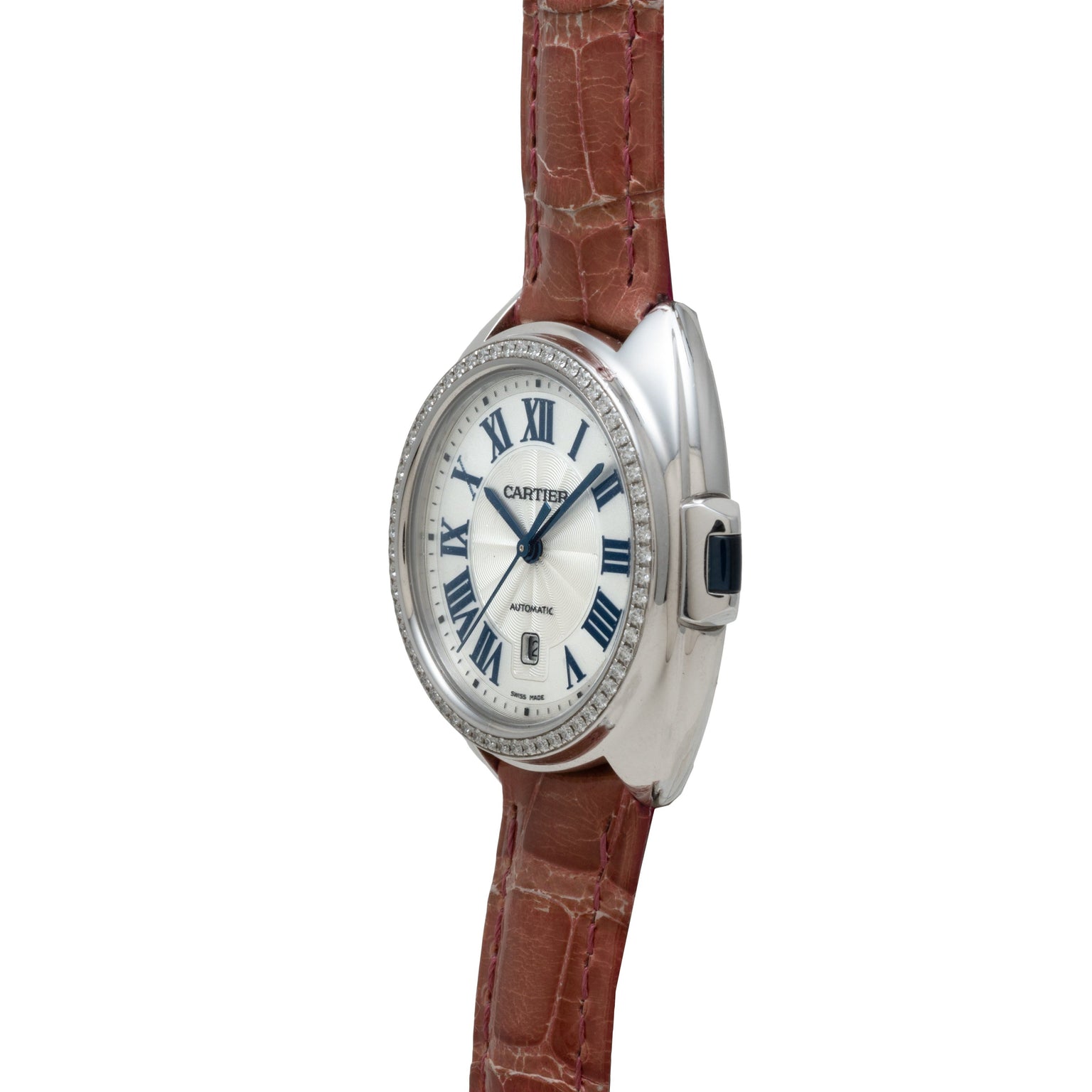 The Cartier Clé de Diamond watch features a silver case, brown leather strap, and Roman numerals on the dial, seen from an angled perspective.