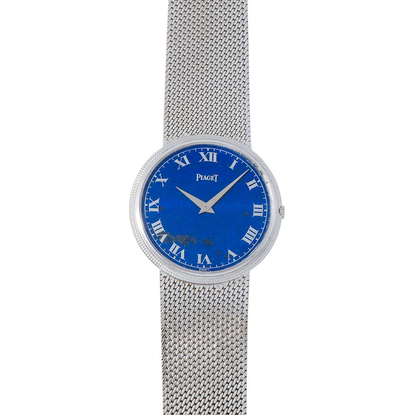 The Piaget Lapis Lazuli Dress Watch features a silver mesh band, blue face, and Roman numerals with the Piaget logo on the dial.