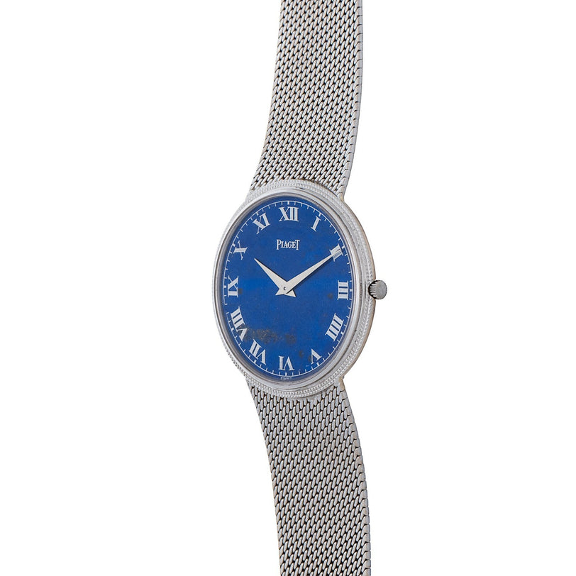 Piagets Lapis Lazuli Dress Watch features a silver mesh strap, a blue lapis lazuli dial with Roman numerals, and the Piaget logo.