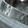 Close-up of the IWC Schaffhausen Aquatimer GST 2000s silver metal bracelet, featuring the engraved IWC logo on its clasp.