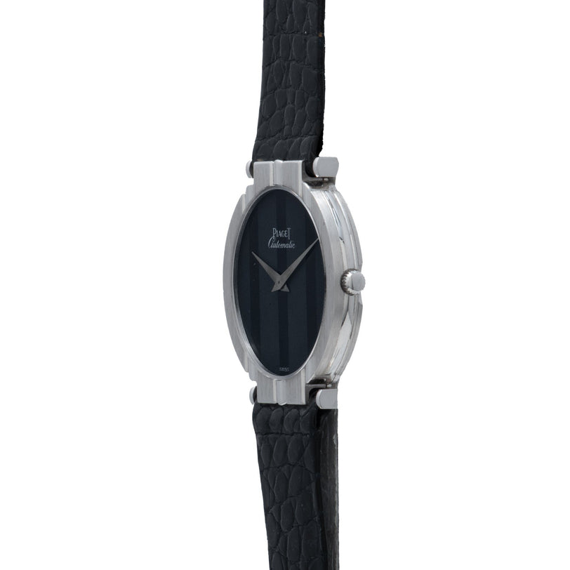 White Gold Ladies wristwatch by Piaget, featuring an oval case with a black leather strap and black dial, shown against a white background.
