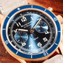 Close-up of the Blancpain Air Command Flyback Chronograph featuring a blue dial, gold case, white numerals, and a leather strap.