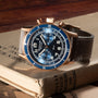 The Blancpain Air Command Flyback Chronograph, featuring a blue face and brown leather strap, rests atop a closed vintage book.