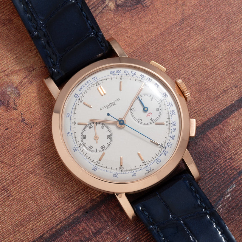 Audemars Piguet Jumbo Two-Register Chronograph with blue leather strap and blue hands rests on a wooden surface, featuring two subdials.