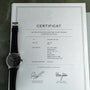 An IWC Schaffhausen Portugieser wristwatch sits atop its certificate of authenticity, dated 14.05.2018.