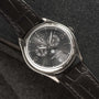 A Patek Philippe Annual Calendar Moonphase wristwatch featuring a black leather strap and detailed dial displaying the date and day.