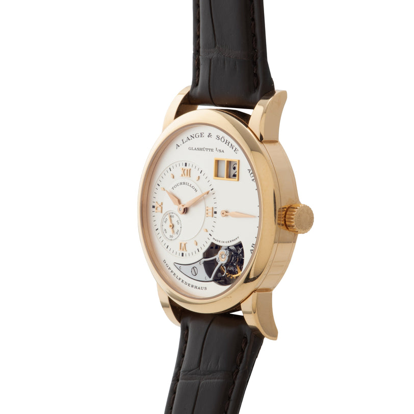Lange & Sohne Lange 1 Tourbillon gold luxury wristwatch featuring a white dial, visible tourbillon, and black leather strap, displayed at an angle.