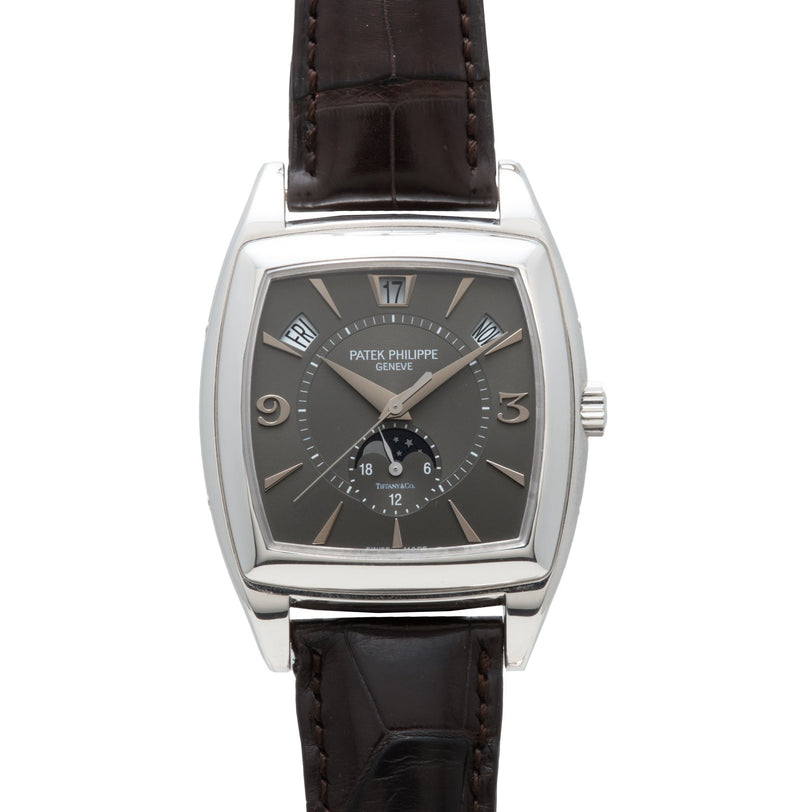 A Patek Philippe Gondolo Annual Calendar wristwatch featuring a dark face, silver markers, and a brown leather strap.