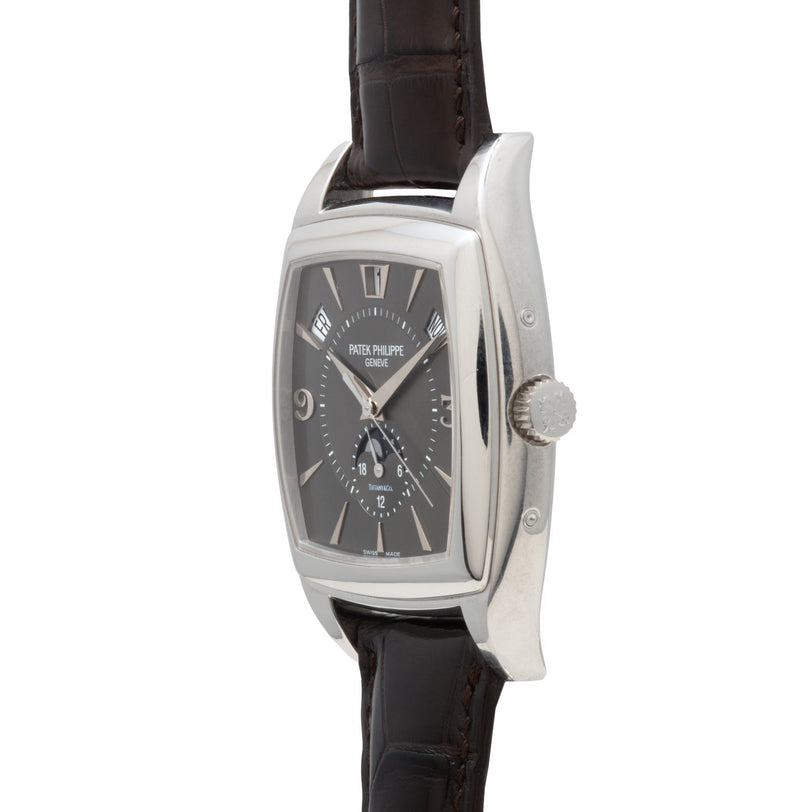 A Patek Philippe Gondolo Annual Calendar wristwatch with a silver case, black dial, and brown leather strap, displayed from a side angle.