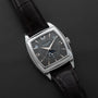 The Patek Philippe Gondolo Annual Calendar features a square black dial and a black leather strap, elegantly displayed on a dark surface.