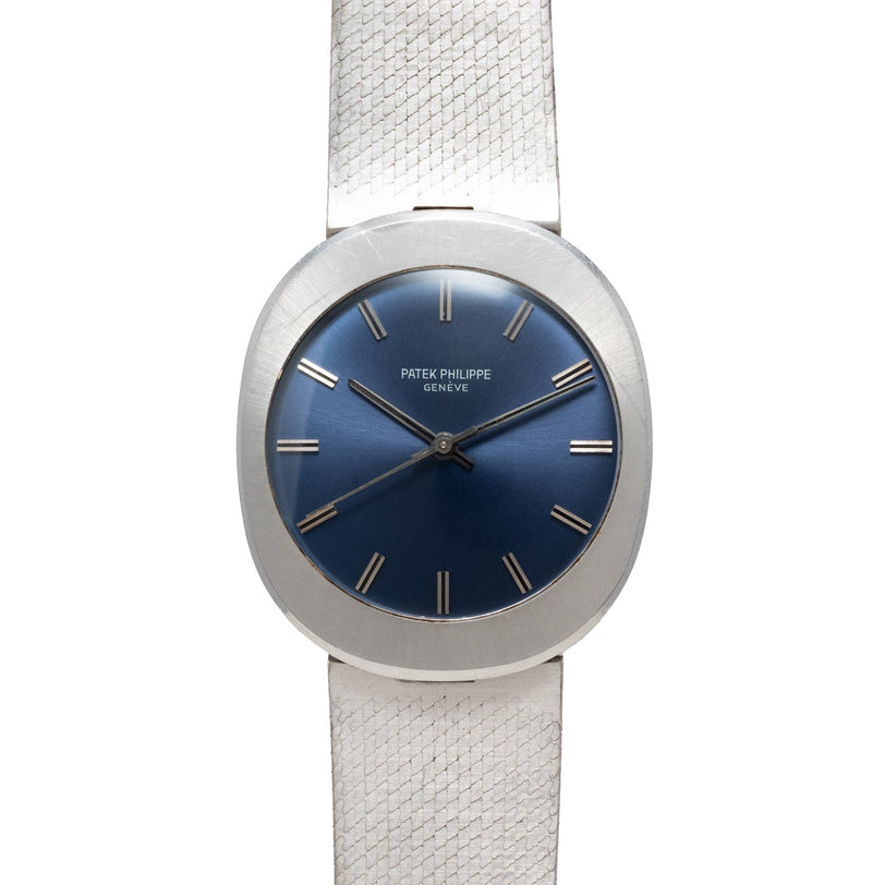 A Patek Philippe Dress Watch UFO featuring a silver case, blue dial, and silver hour markers on a textured silver band.