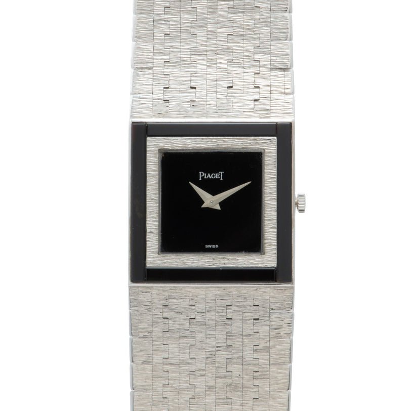 A white gold Piaget Onyx dress watch featuring a textured band and a black square face with silver hands.
