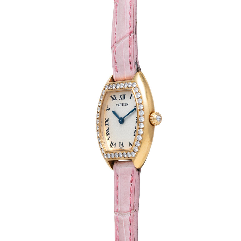 Cartier Tortue watch featuring a diamond bezel, Roman numerals, and a pink leather strap, displayed against a white background.