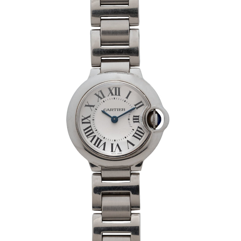 The Cartier Ballon Bleu watch features Roman numerals, blue hands, and a metal link bracelet, displayed against a white background.