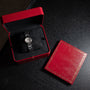 A Cartier Ballon Bleu silver wristwatch is displayed on a dark surface, presented in a red box with a matching red lid.