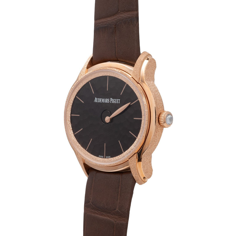 The Audemars Piguet Millenary Philosophique features a rose gold case, black dial, and brown leather strap.