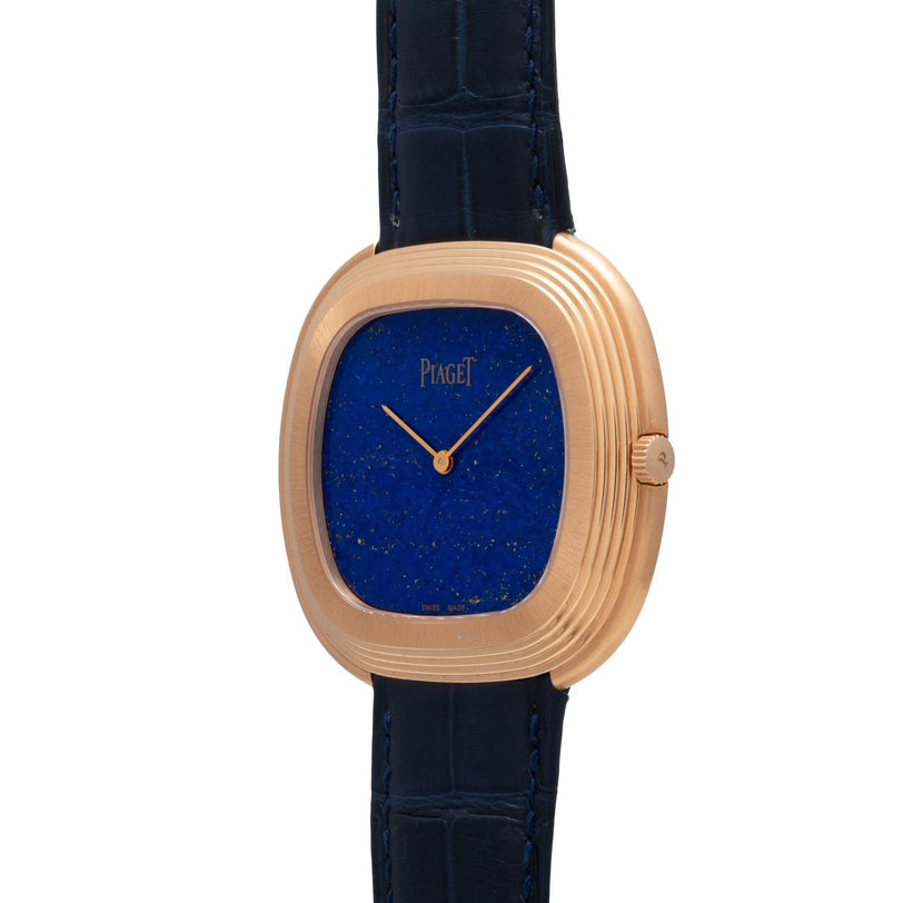 A Piaget Black Tie Andy Warhol gold wristwatch with a blue dial and black leather strap, displayed at an angle.