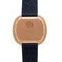The back of a Piaget Black Tie Andy Warhol watch with a black textured leather strap and engraved markings.