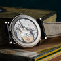 A close-up of the intricate inner mechanism of the Patek Philippe Perpetual Calendar Moonphase wristwatch displayed on a vintage book.