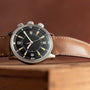 The Jaeger-LeCoultre Tribute to Polaris wristwatch with a brown leather strap is elegantly displayed on a wooden surface.