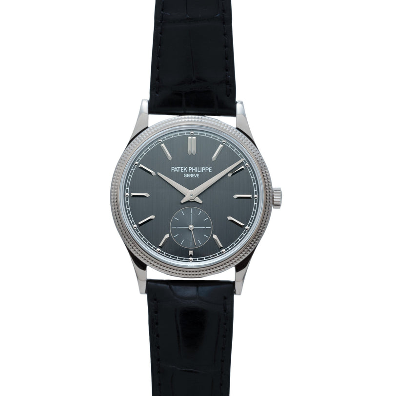 The Patek Philippe Calatrava wristwatch features a black leather strap and a dark gray dial for elegant time display.