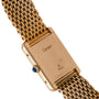 Back of a Cartier Tank Louis wristwatch with Paris engraving and blue cabochon crown, on a gold link band.