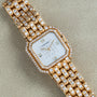 The Cartier Ceinture Paris Diamond watch features a gold case, diamond bezel and bracelet, and Roman numerals on a white face.