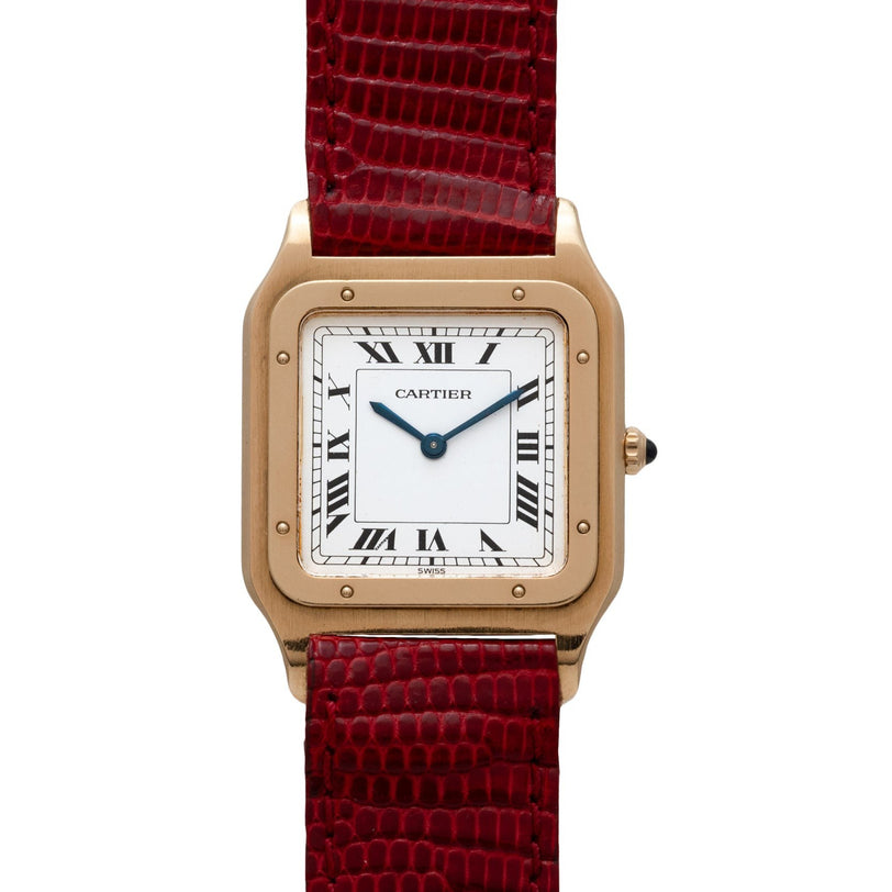 A Cartier Santos Dumont watch with a square face, Roman numerals, and a red textured leather strap.