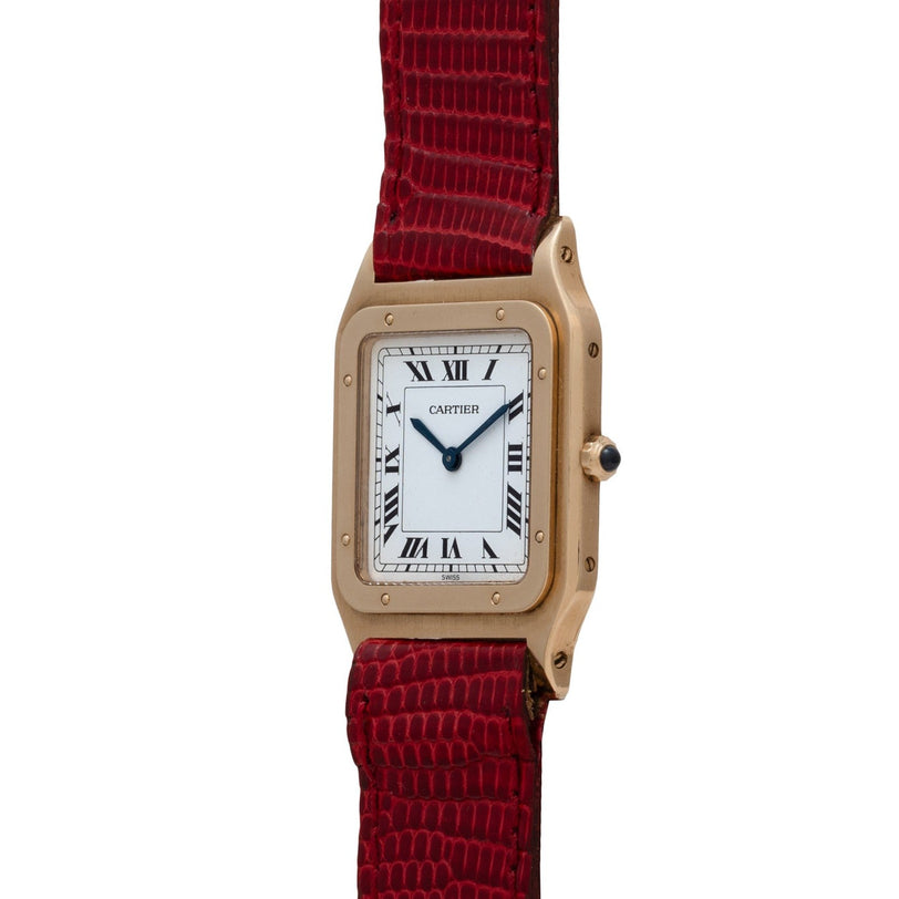 The Cartier Santos Dumont features a square face with Roman numerals and a red textured leather strap.