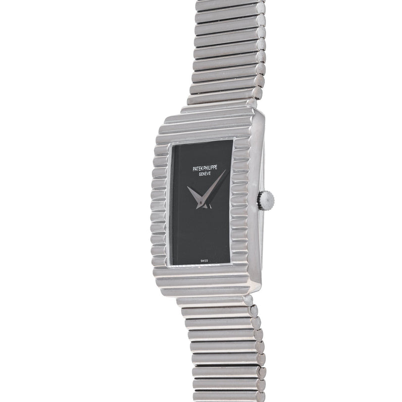 A Patek Philippe Ellipse Gondolo Onyx wristwatch featuring a silver case, black rectangular face, and ridged metal band.