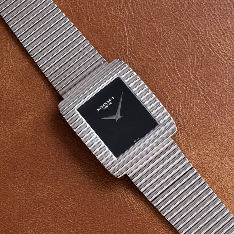 The Patek Philippe Ellipse Gondolo Onyx features a black square face with silver stripes and a brown leather strap.