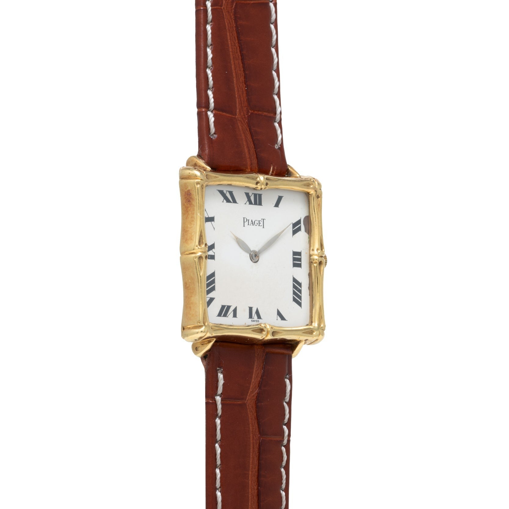 The Piaget Bamboo Dress Watch features a square gold case, white dial with Roman numerals, and a brown leather strap accented by white stitching.