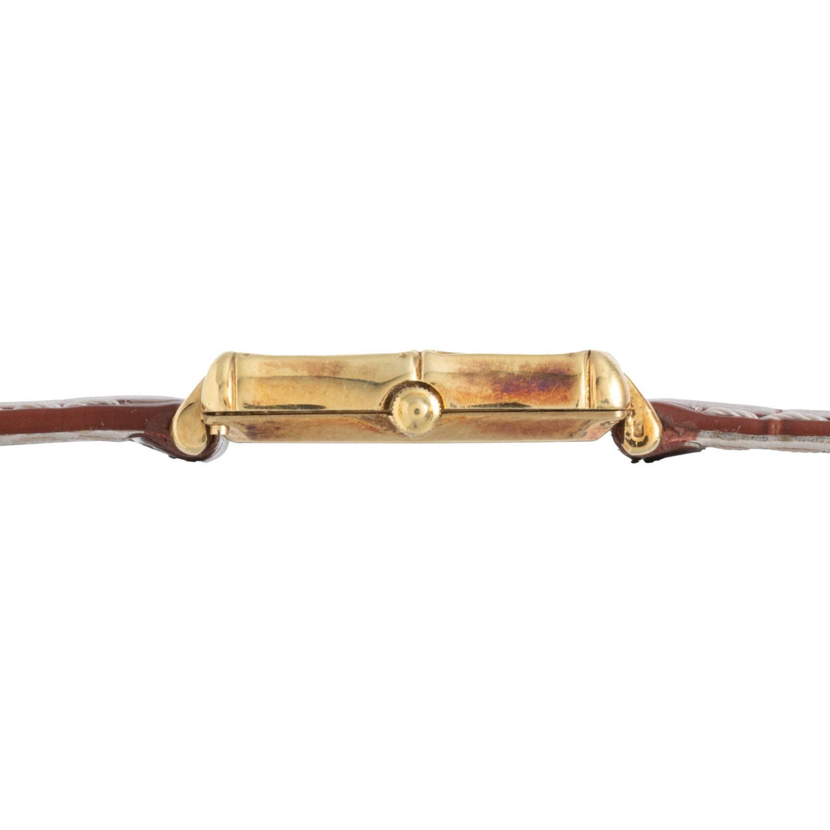Side view of the Piaget Bamboo Dress Watch featuring a gold case, brown leather strap, and a central round crown.