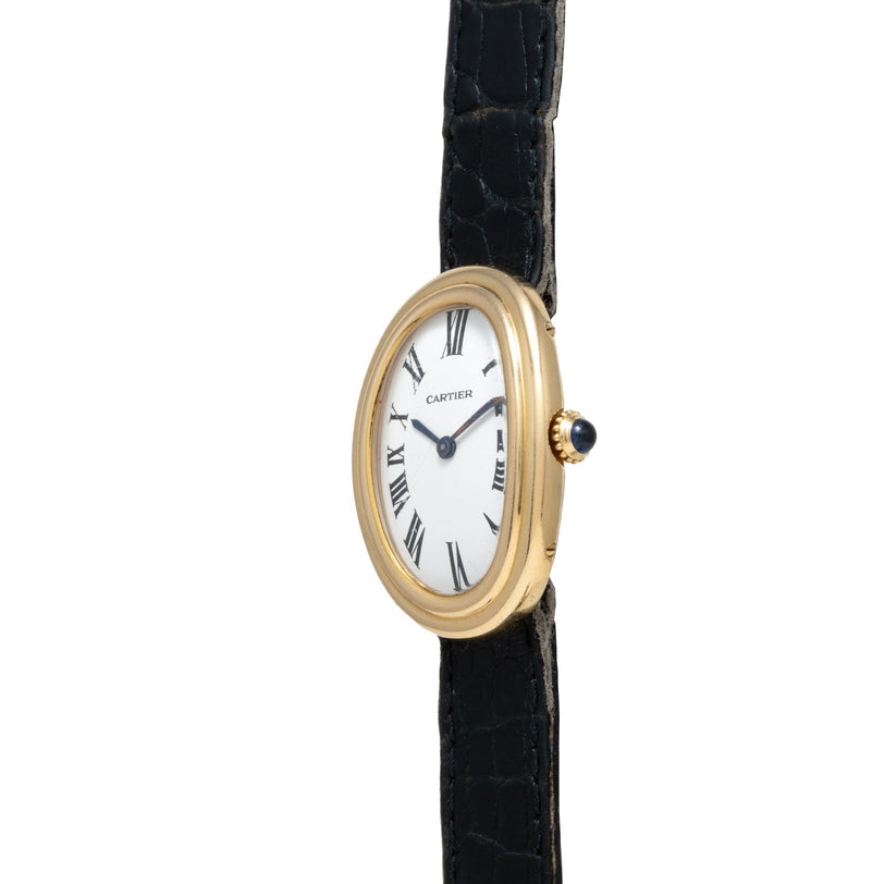 Cartier Baignoire watch featuring a gold oval case, white dial with black Roman numerals, and a black leather strap.